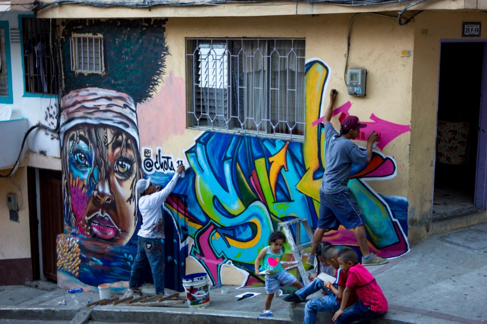 Local Comuna 13 graffiti crew painting as kids watch.jpg